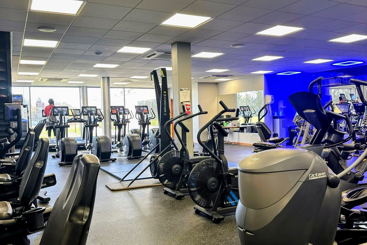Commercial gym cleaning crew disinfecting fitness equipment in a Raleigh, NC facility